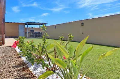 a backyard with a garden with a house at Bungalow con piscina privada in Conil de la Frontera