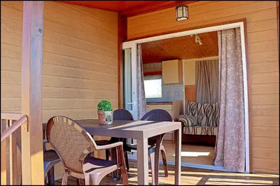 a table and chairs on the porch of a house at Bungalow con piscina privada in Conil de la Frontera
