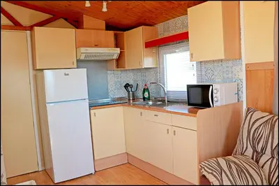 a kitchen with a white refrigerator and a microwave at Bungalow con piscina privada in Conil de la Frontera
