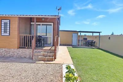 a small house with a deck and a patio at Bungalow con piscina privada in Conil de la Frontera