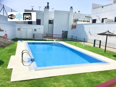 a swimming pool in the yard of a house at Ático Premium Conil con 2 terrazas, parking, piscina, Aire Ac y WIFI -SOLO FAMILIAS Y PAREJAS- in Conil de la Frontera
