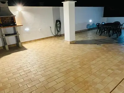 a room with a wooden floor and a table and chairs at Ático Premium Conil con 2 terrazas, parking, piscina, Aire Ac y WIFI -SOLO FAMILIAS Y PAREJAS- in Conil de la Frontera