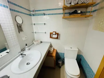 a bathroom with a white toilet and a sink at Ático Premium Conil con 2 terrazas, parking, piscina, Aire Ac y WIFI -SOLO FAMILIAS Y PAREJAS- in Conil de la Frontera