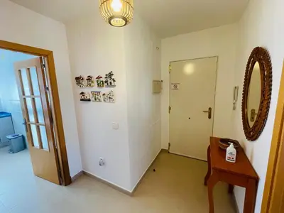 a room with a table and a mirror and a door at Ático Premium Conil con 2 terrazas, parking, piscina, Aire Ac y WIFI -SOLO FAMILIAS Y PAREJAS- in Conil de la Frontera