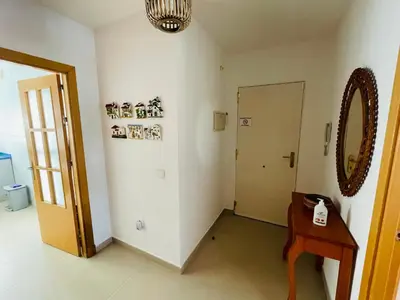 a room with a hallway with a table and a door at Ático Premium Conil con 2 terrazas, parking, piscina, Aire Ac y WIFI -SOLO FAMILIAS Y PAREJAS- in Conil de la Frontera