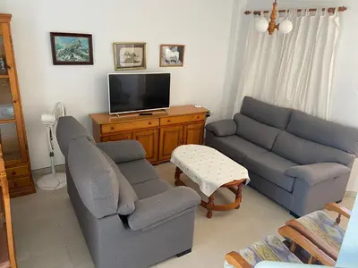 a living room with two couches and a tv at Victoria Chipiona Unifamiliar in Chipiona
