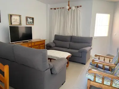 a living room with two couches and a tv at Victoria Chipiona Unifamiliar in Chipiona