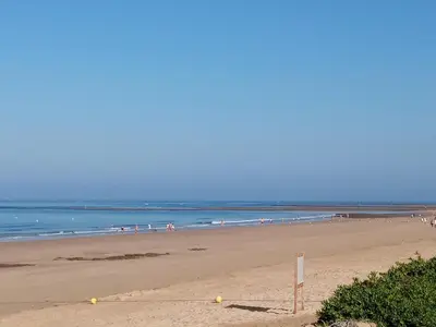 a beach with a group of people in the water at Victoria Chipiona Unifamiliar in Chipiona