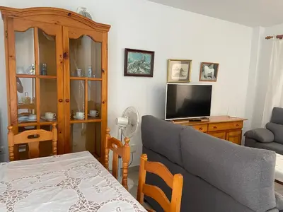 a living room with a couch and a television at Victoria Chipiona Unifamiliar in Chipiona