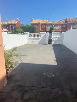 a patio with a white fence and some houses at Victoria Chipiona Unifamiliar in Chipiona