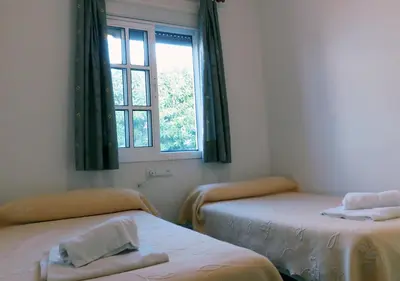 a room with two beds and a window at Los Pinos 4 in Chiclana de la Frontera