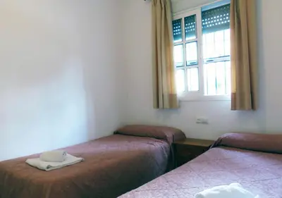 a room with two beds and a window at Los Pinos 4 in Chiclana de la Frontera