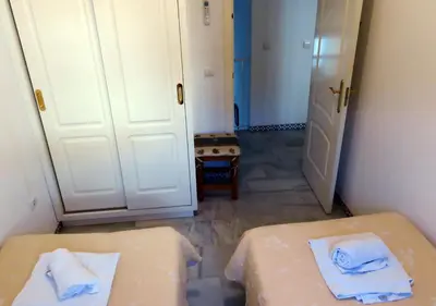 a room with a bed and a door with towels at Los Pinos 4 in Chiclana de la Frontera