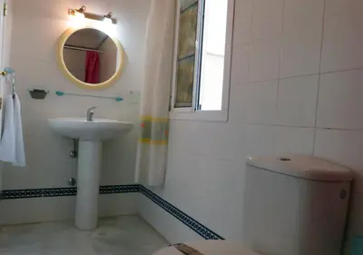 a bathroom with a sink and a toilet and a mirror at Los Pinos 4 in Chiclana de la Frontera