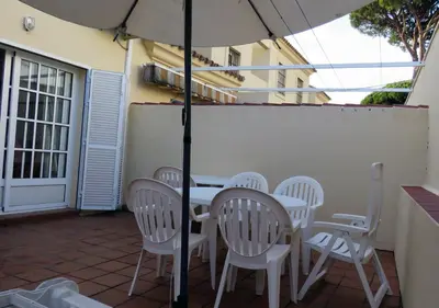 a table and chairs with an umbrella on a patio at Los Pinos 4 in Chiclana de la Frontera