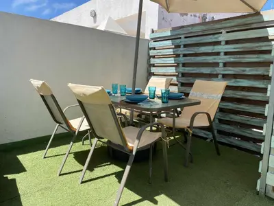 a table with two blue bowls and wine glasses at Fantástico ático en el casco antiguo en a la playa in Cádiz