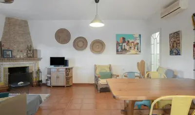 a house with a grass yard with a building at Chalet la barrosa a 800 mts playa in Chiclana de la Frontera
