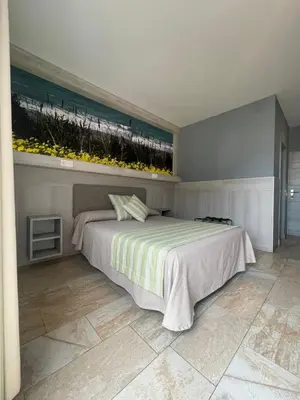 a bedroom with a bed with a view of the beach at Hostal Noli in Chiclana de la Frontera