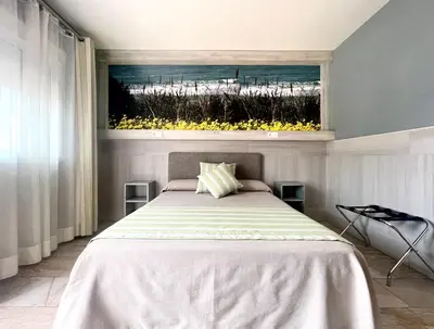 a bedroom with a bed with a view of the ocean at Hostal Noli in Chiclana de la Frontera