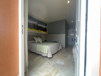 a bedroom with a bed and a painting on the wall at Hostal Noli in Chiclana de la Frontera