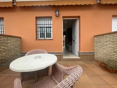 a patio with a table and chairs and a building at Hostal Noli in Chiclana de la Frontera