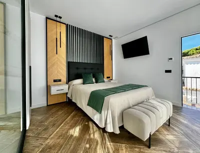 a bedroom with a large bed and a tv at Hostal Noli in Chiclana de la Frontera