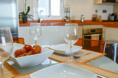 a table with two wine glasses and a bowl of tomatoes at HORIZONTE Sunny Home by Cadiz4Rentals in Cádiz