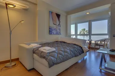 a bedroom with a bed and a table and windows at HORIZONTE Sunny Home by Cadiz4Rentals in Cádiz