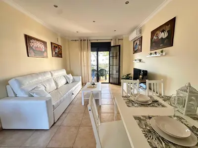 a living room with a white couch and a table at Coto de Sancti Petri in Chiclana de la Frontera