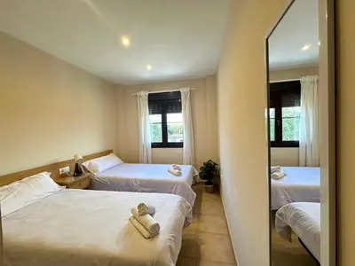 a hotel room with two beds and a mirror at Coto de Sancti Petri in Chiclana de la Frontera