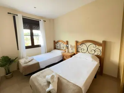 a bedroom with two beds and a window at Coto de Sancti Petri in Chiclana de la Frontera