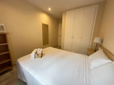 a bedroom with a large white bed with a book at Novo Sancti Petri Atardecer Planta baja in Chiclana de la Frontera