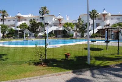 a fence in front of a swimming pool at Novo Sancti Petri Atardecer Planta baja in Chiclana de la Frontera