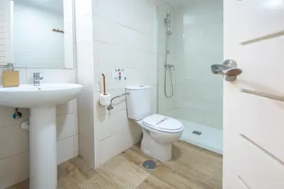 a white bathroom with a toilet and a sink at Apartamento Albatro´s suite in Cádiz