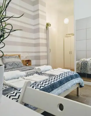 two beds in a room with a striped wall at Los Patios de la Caleta in Cádiz