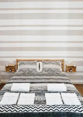 a bedroom with a large bed with striped walls at Los Patios de la Caleta in Cádiz