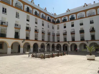 a large building with a courtyard in front of it at Los Patios de la Caleta in Cádiz