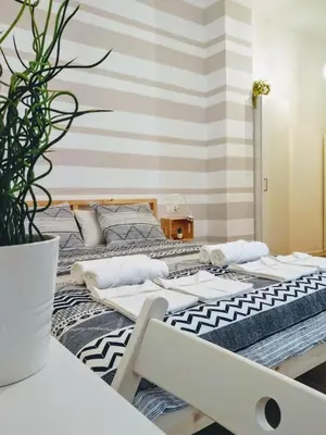 a bedroom with two beds and a table at Los Patios de la Caleta in Cádiz