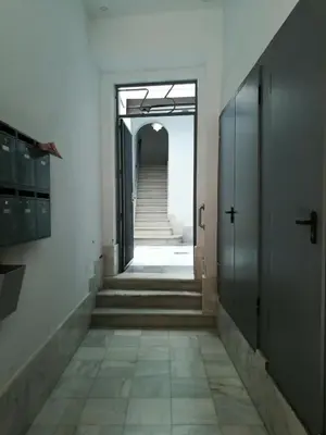 an empty hallway with stairs and an open door at Sopranis del MAR Apartamento centro Cádiz, junto playa y estación in Cádiz