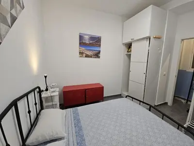 a bedroom with a bed and a red cabinet at Sopranis del MAR Apartamento centro Cádiz, junto playa y estación in Cádiz