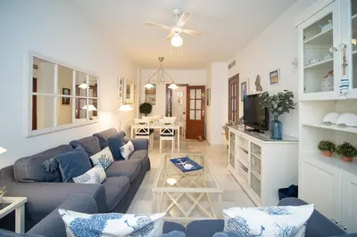 a living room with a couch and a table at Sol y Vida, Apartamentos Living Sur in Sanlúcar de Barrameda