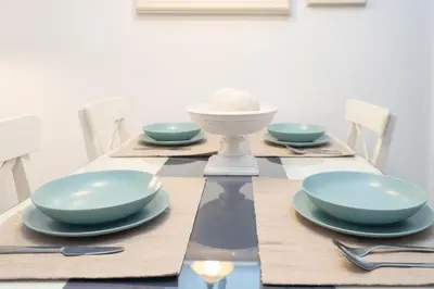 a dining table with blue bowls and plates on it at Sol y Vida, Apartamentos Living Sur in Sanlúcar de Barrameda