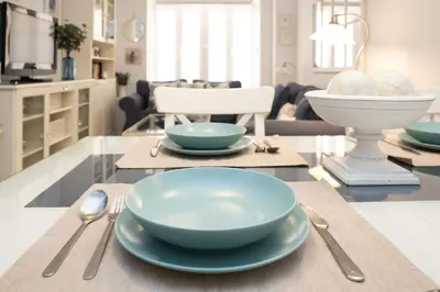a table with two bowls and silverware on it at Sol y Vida, Apartamentos Living Sur in Sanlúcar de Barrameda