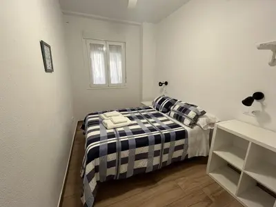 a bedroom with a bed with a black and white blanket at Tu Rincón Gaditano PLAYA y WIFI Grupo AC Gestion in Cádiz
