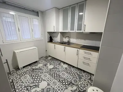 a kitchen with white cabinets and a tile floor at Tu Rincón Gaditano PLAYA y WIFI Grupo AC Gestion in Cádiz