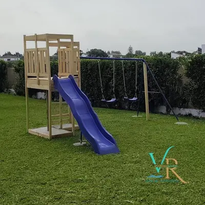 a playground with a blue slide and a swing at Villa la Dehesa in Conil de la Frontera