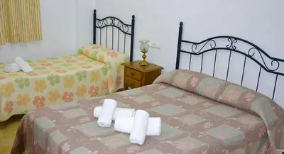 a bedroom with two beds with white towels on the bed at Villa la Dehesa in Conil de la Frontera