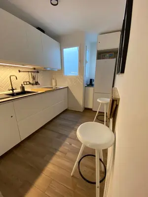 a kitchen with two stools and a sink and a refrigerator at Charito 18 in Cádiz