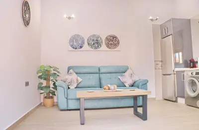 a living room with a blue couch and a table at Chalet Sultan con piscina in Conil de la Frontera