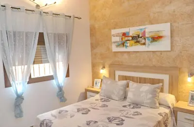 a bedroom with a bed and a window at Chalet Sultan con piscina in Conil de la Frontera